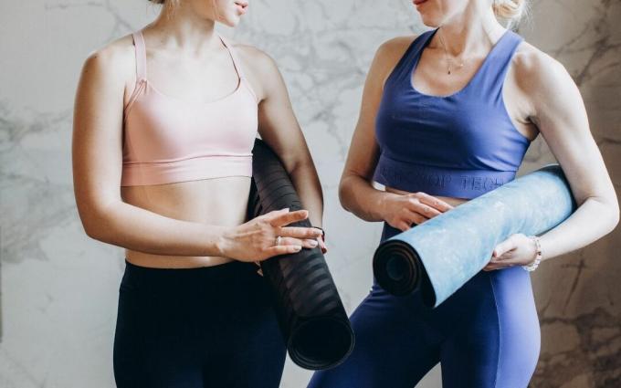 Mujeres con colchonetas de yoga hablando