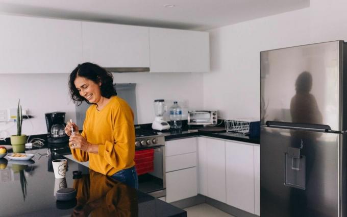 Mujer con altavoz inteligente en casa