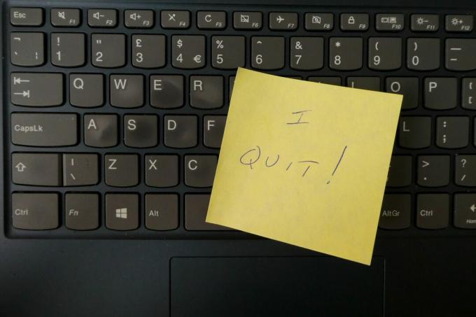 Renuncio escrito en una nota post-it pegada a un teclado