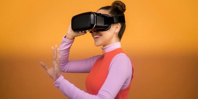 Mujer sonriendo mientras usa un casco de realidad virtual negro