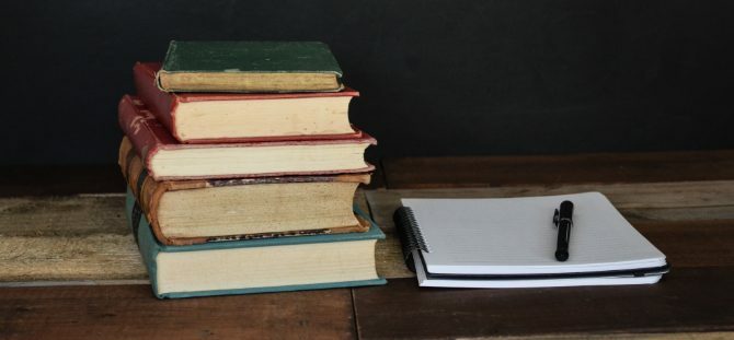 Pila de libros y bloc de notas para investigación